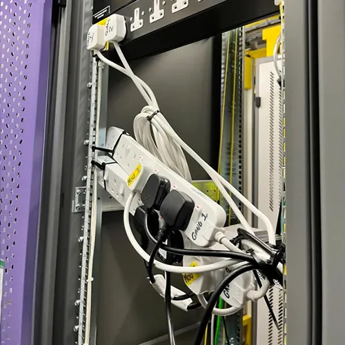 Multiple extension cords hanging with many plugs plugged in